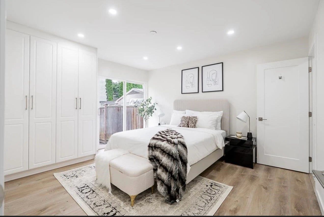 Bright staged bedroom with framed line-art prints, a faux-fur throw and pale wood floors