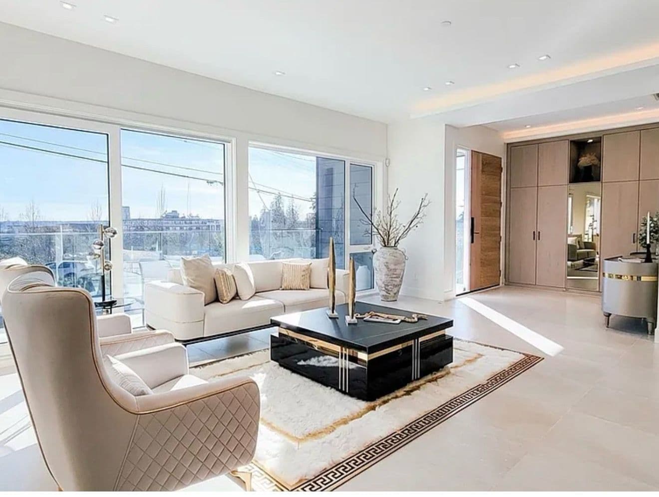 Staged living room and entry foyer with floor-to-ceiling windows
